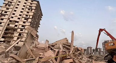 Hasarlı bina iş makinesi operatörünün üzerine yıkıldı